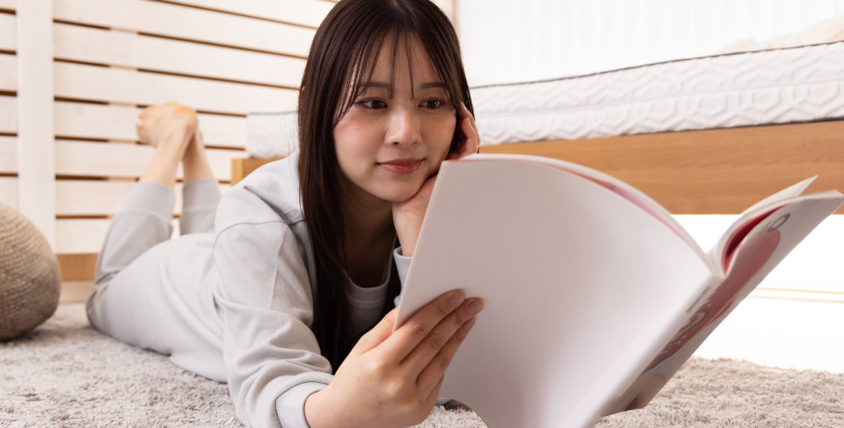 リカバリ―ウェア「ねむる惑星」オールシーズンを着て読書する女性